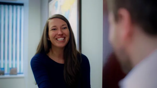 A woman smiling at a mirror.