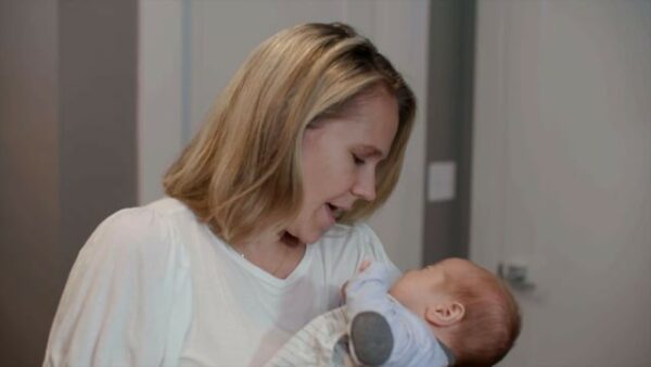 A woman is holding a baby in her arms.