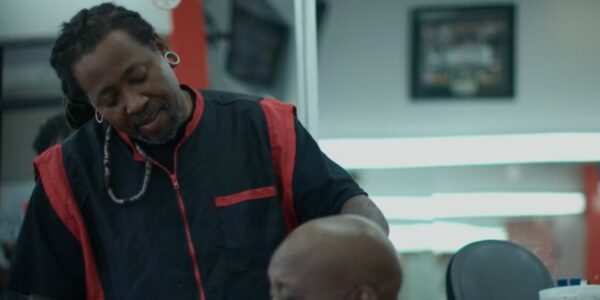 A man is getting his hair cut in a barber shop.