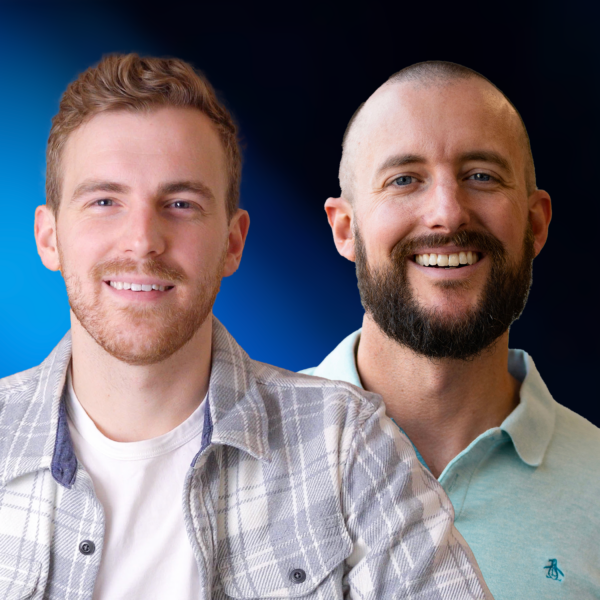 Two men smiling in front of a blue background.