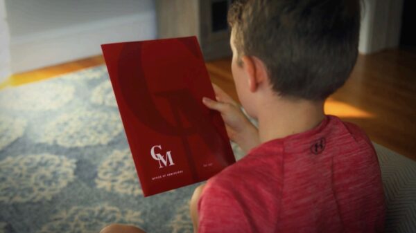 A young boy reading a book on the floor.