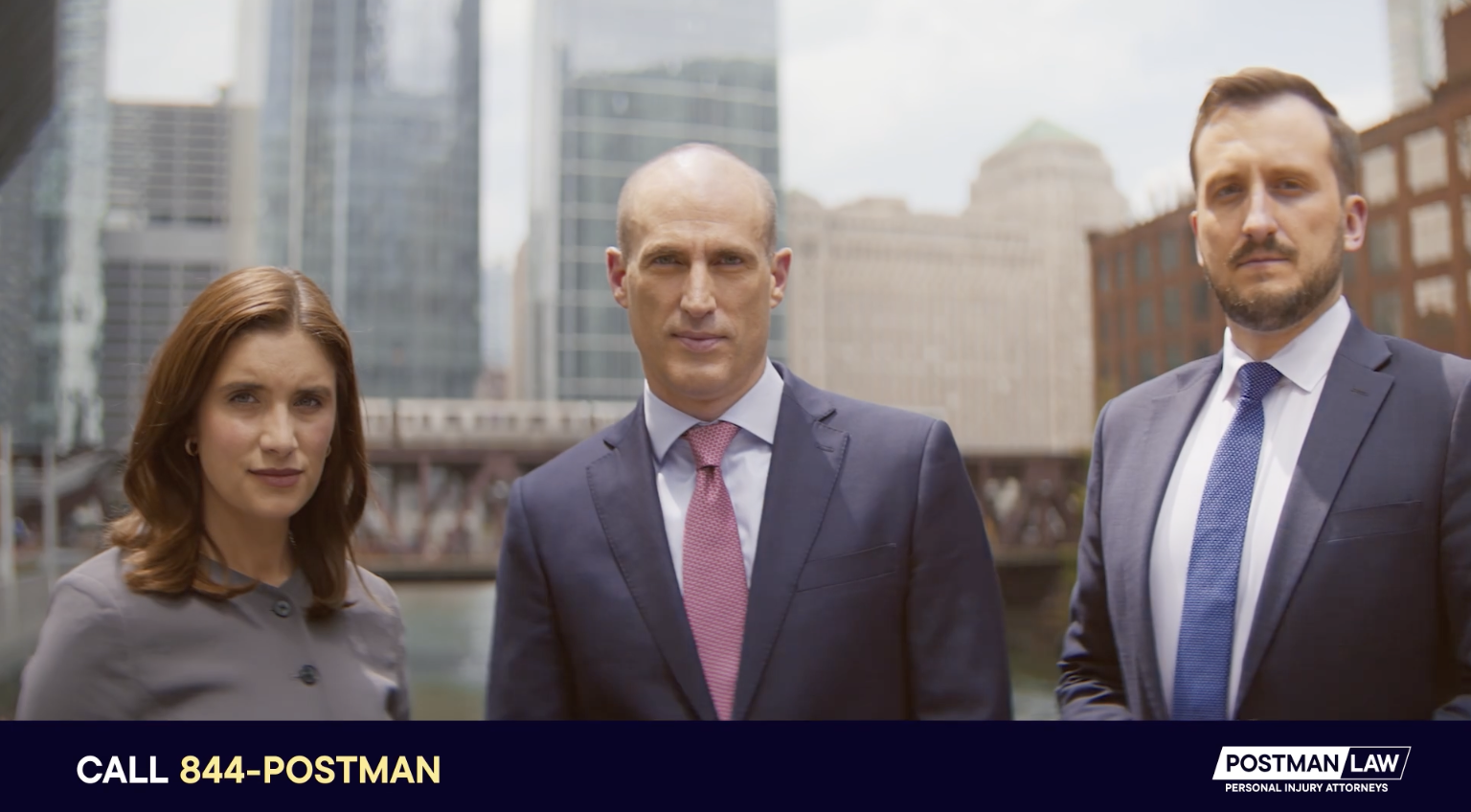 Three people in business attire stand outdoors in a city with tall buildings in the background; a banner at the bottom promotes Postman Law and displays a phone number.
